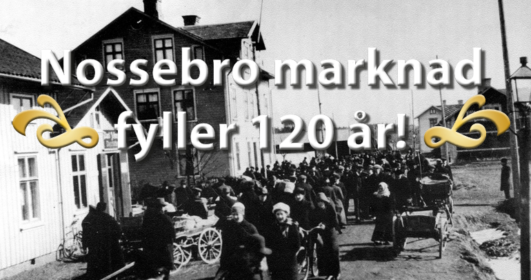 Den svartvita bilden visar Nossebro längs Storgatan runt sekelskiftet 1900. Många människor går mitt i gatan.