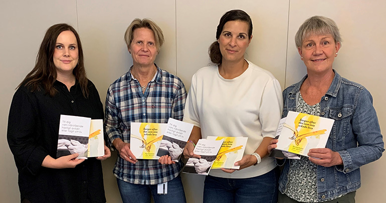 Malin Gustafsson, folkhälsostrateg i Tidaholm och Maria Timm, Processledare psykisk hälsa på Skaraborgs kommunalförbund, överlämnar broschyr och böcker till Malena Engqvist och Jeanette Arvidsson, dödsfallshandläggare på Polisen i Skaraborg