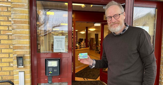 Gunnar Källström, biblioteksansvarig, visar upp det passerkort och den kortläsare som nu finns vid entrén till biblioteket i Nossebro. Dessa möjliggör inpassering i lokalerna även efter det att personalen gått hem för dagen.